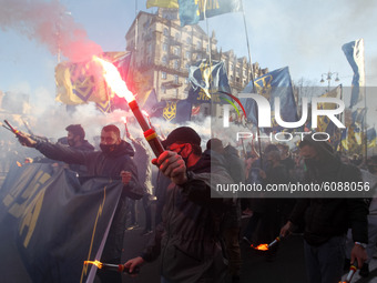 Ukrainians burn flares during a march to the 78th anniversary of the founding of the Ukrainian Insurgent Army in central Kyiv, Ukraine on 14...