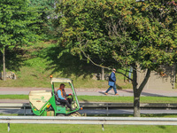 Worker mowing the grass on a self-propelled mower is seen in Gdynia, Poland, on 17 September 2020  (