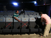 Indian worker set up the social distance making to chair and others at the inside Cinema hall as cinemas reopen with a special screening for...