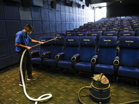 A worker cleaning the seats of a cinema hall  as cinemas reopen as part of unlock 5.0 in India, amid the novel coronavirus (COVID-19) pandem...