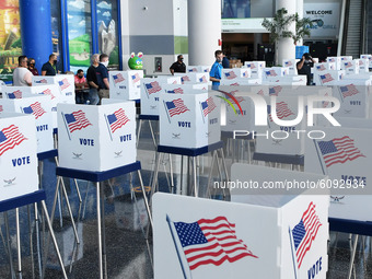 Election workers set up voting booths at an early voting site established by the City of Orlando and the Orlando Magic at the Amway Center,...