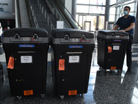 A worker brings tabulation machines to an early voting site established by the City of Orlando and the Orlando Magic at the Amway Center, th...