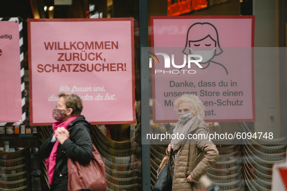 shoppers with face mask wait in line to get into a retail store in Duesseldorf, Germany, on October 16, 2020 amid the COVID-19 pandemic. 