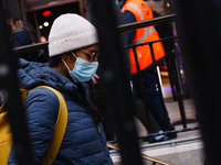 A woman wearing a face mask, required on public transport, enters Oxford Circus Station in London, England, on October 16, 2020. London is t...
