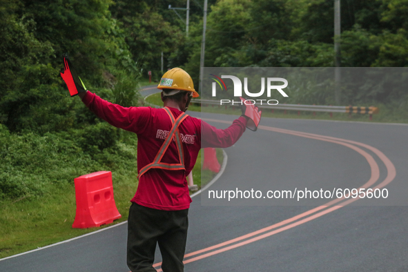 Worker in Marilaque Road directing the riders on October 17, 2020 in a curve lane to avoid collision where other workers are installing land...