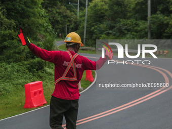 Worker in Marilaque Road directing the riders on October 17, 2020 in a curve lane to avoid collision where other workers are installing land...
