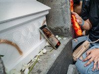A digital photograph of three-month-old daughter of political detainee Reina Mae Nasino, is placed beside her coffin before she is buried, i...