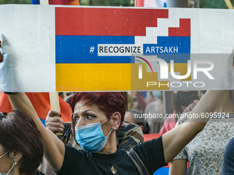 A woman holds a banner asking for the recognition of Karabakh as an independent state in the international community in a demonstration in Y...