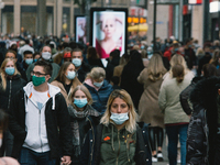 Crowd of people with face masks walking in the shopping block in Cologne, Germany, on October 17, 2020 as NRW state mandate face covering in...