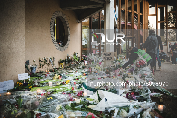 A woman lays flowers at the entrance of a middle school in Conflans-Sainte-Honorine, 30kms northwest of Paris, on October 17, 2020, after a...