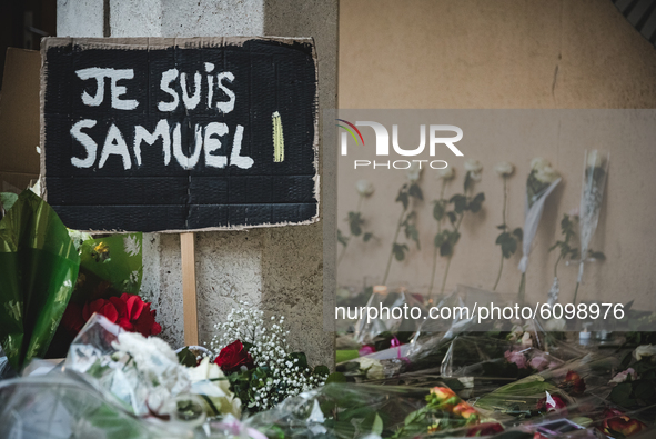 A photo shows flowers and a placard reading 'I am a teacher, I am Samuel' at the entrance of a middle school in Conflans-Sainte-Honorine, 30...