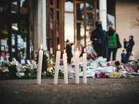 A photo shows flowers, candles and a placard reading 'I am a teacher, I am Samuel' at the entrance of a middle school in Conflans-Sainte-Hon...
