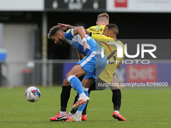 Will Smith and Warren Burrell in action with Barrow's Bradley Barry uring the Sky Bet League 2 match between Harrogate Town and Barrow at We...