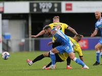 Will Smith and Warren Burrell in action with Barrow's Bradley Barry uring the Sky Bet League 2 match between Harrogate Town and Barrow at We...