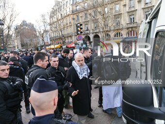 This picture taken on December 29, 2012, in Paris, shows the President of the Cheikh Yassine collective Abdelhakim Sefrioui (C with a white...