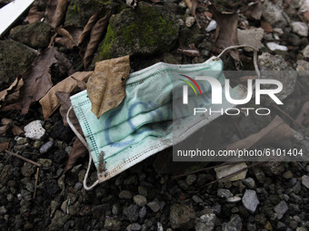 This is photo illustration, a disposable surgical face mask  is seen lying on a debris rock during the new coronavirus pandemic in Jakarta,...