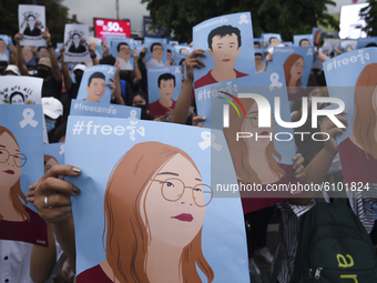 Thai protesters hold hold up posters of protest leaders who have been arrested during an anti-government protest at the Victory Monument in...