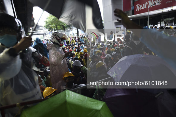 Thai protesters stand behind a barricade during an anti-government protest at the Victory Monument in Bangkok, Thailand, 18 October 2020. 