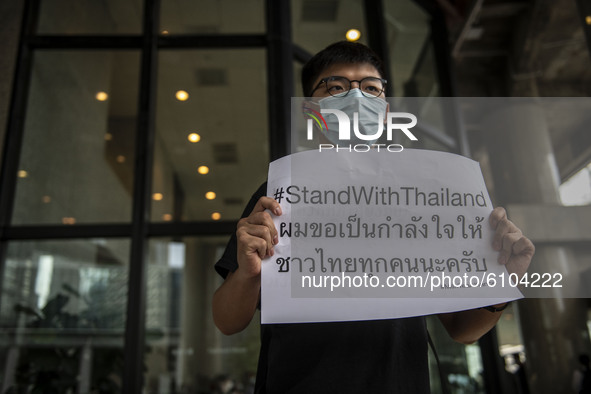 Pro-Democracy Activist Joshua Wong is seen holding up a placard which reads Stand with Thailand outside the building where the Royal Thai Co...