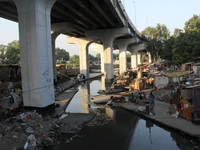 A view of a slum dwelling cluster along a drain under Baba Banda Singh Bahadur Setu near INA Colony, on October 20, 2020, in New Delhi, Indi...