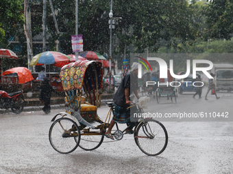 A man is pulling rickshaw during the rainfall in Dhaka, Bangladesh on October 21, 2020. (
