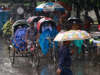People make their way during the rainfall in Dhaka, Bangladesh on October 21, 2020.  (