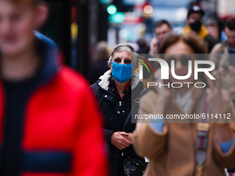 An elderly woman wears a face mask amid shoppers on Oxford Street in London, England, on October 22, 2020. Retail sales figures from the UK...