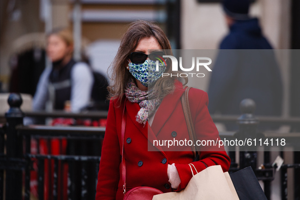 A woman wears a face mask amid shoppers at Oxford Circus in London, England, on October 22, 2020. Retail sales figures from the UK Office fo...