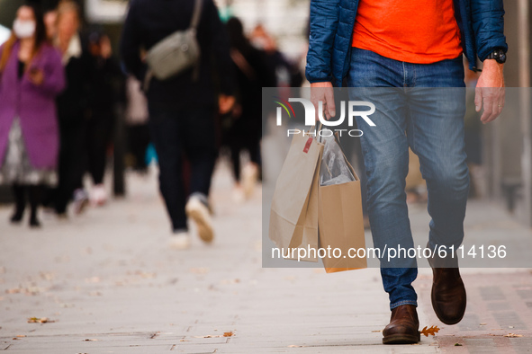 A man carries bags of shopping along Oxford Street in London, England, on October 22, 2020. Retail sales figures from the UK Office for Nati...
