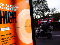 A government public information notice reminding people of 'High' (or 'Tier 2') coronavirus restrictions lights up the advertising panel of...