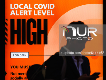 A government public information notice reminding people of 'High' (or 'Tier 2') coronavirus restrictions lights up the advertising panel of...