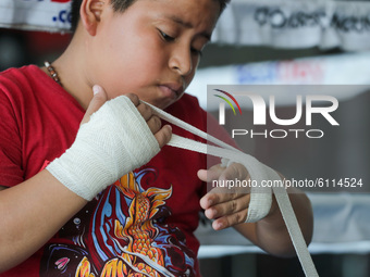 Johnny Garcia Jimenez, an 11-year-old boy, he puts the bandages on his fists before starting his training amid Covid-19 pandemic on October...
