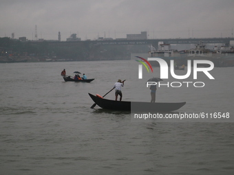 People cross over the Buriganga River by small wooden boats on a rainy day in Dhaka, Bangladesh on October 23, 2020.  Rainfall occurs in var...