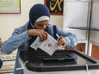  A woman casts her vote into a ballot box inside a polling station at Dokki district during the first round of the first phase of the Egypti...