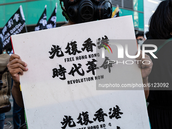 A protester holding a sign with the sentences Free Hong Kong and Revolution of your times on October 25, 2020 in Taipei, Taiwan. On Saturday...