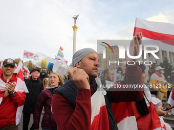 People carry historical white-red-white flags of Belarus during a rally of solidarity with Belarusian protests on Independence Square in Kyi...