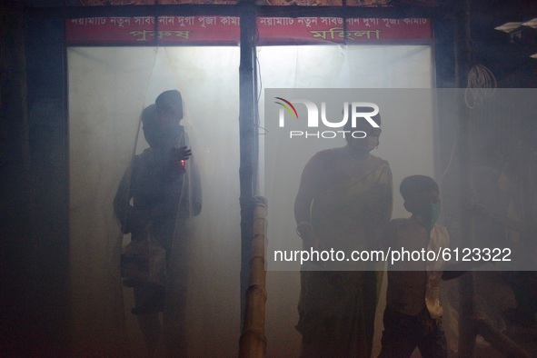 A family entering temple through disinfection tunnel aimed global pandemic COVID-19 to celebrate Durga Puja in Narayanganj, Bangladesh on Oc...