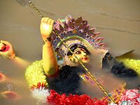Hindu goddess Durga into the brahmaputra  river during the immersion ceremony of Durga Puja in Guwahati, india on October 26, 2020. (
