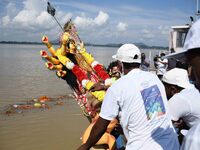 Municipal workers immerse an idol of the Hindu goddess Durga in the waters of the river Brahmaputra on the last day of the Durga Puja festiv...