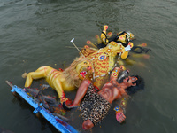 Devotees perform rituals as they are taking an idol of the Hindu goddess Durga for its immersion into a river, amid the coronavirus pandemic...