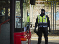 A Police Officer next to an urban bus during a police control at one of the main entrances to the city of Granada on October 26, 2020 in Gra...