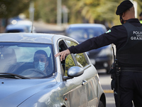 A police officer give instructions a car to stay aside during a police control at one of the main entrances to the city of Granada on Octobe...