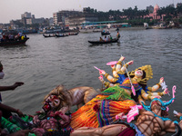 Hindu devotees submerge a clay idol of the Hindu goddess Durga on the Buriganga River during the final day of the Durga Puja festival, in Dh...