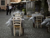   Wind moves the tablecloths of the tables of a deserted restaurant in Trastevere district as Italy is facing a surge in the coronavirus dis...
