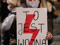 A young woman holds a sign with the words 