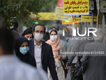 An Iranian woman wearing a protecting face mask to prevent herself of infection by the new coronavirus disease (COVID-19) looks on as she wa...