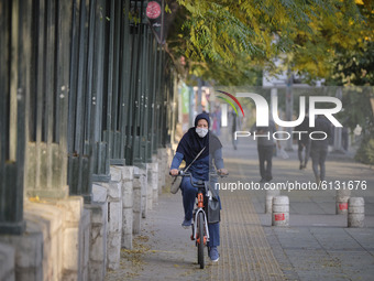 An Iranian woman wearing a protective face mask to prevent herself of infection by the new coronavirus disease (COVID-19) rides bicycle alon...