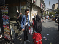 A female member of Iran Red Crescent Society asks a man to wear a protective face mask to prevent himself of infection by the new coronaviru...