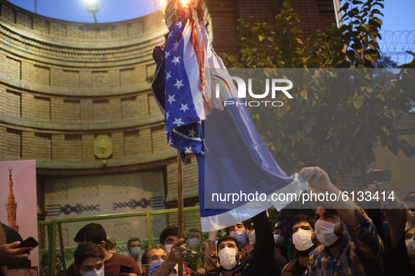 Iranian protesters burn the U.S. and French flags during a protest gathering in front of the French embassy in Tehran on October 28, 2020. P...