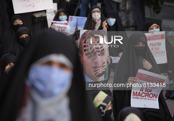 Iranian female protesters hold anti French President Emmanuel Macron placards during a protest gathering in front of the French embassy in T...